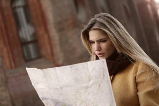 A woman intently reads a map outdoors, highlighting navigation and exploration.