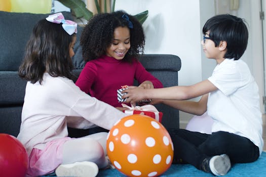 Children enjoying a birthday celebration with gifts and balloons indoors.